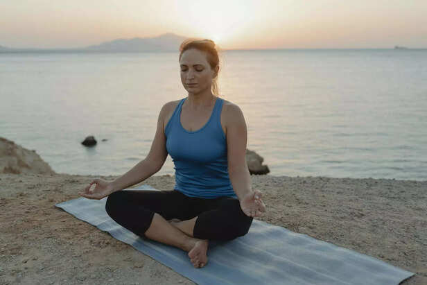 Person doing yoga at sunrise outdoors