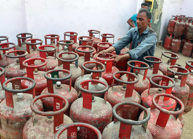 A delivery man loads refilled LPG cylinder following a ...