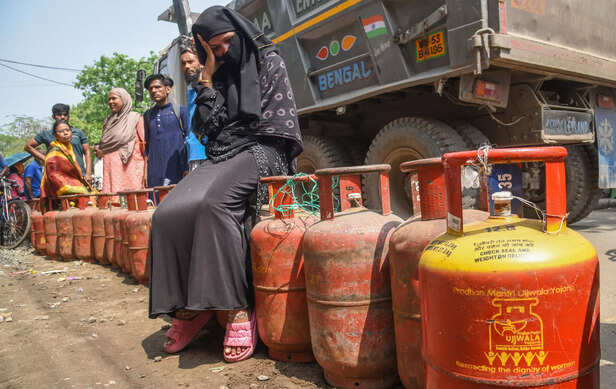 People wait outside a gas agency to refill the LPG cylind...