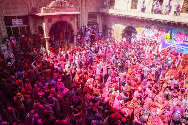 Vrindavan, Mar 02 (ANI): People play Holi with flower petals and colours as part...