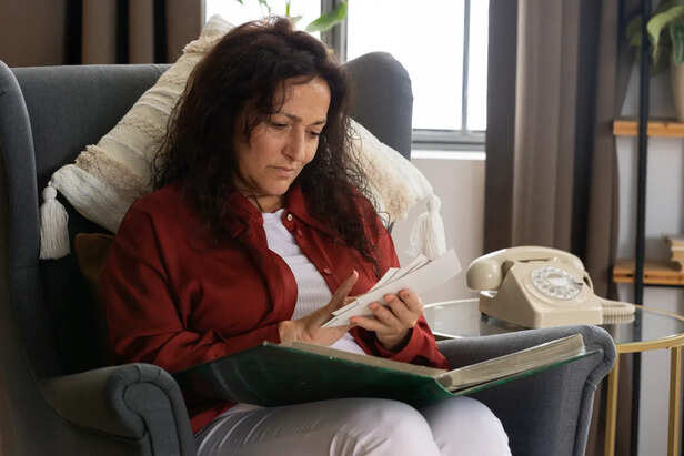 Woman sitting silently while holding old memories