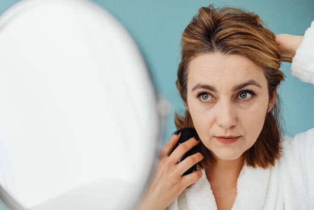 Woman Looking Closely At a Single White Hair
