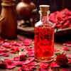 Pure rose water bottle beside fresh rose petals