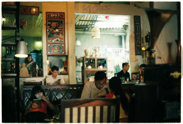 Young Adult Sitting Quietly in a Crowded Café