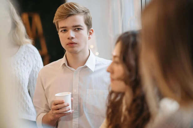 Young Adult Looking Thoughtful Among a Group of Friends