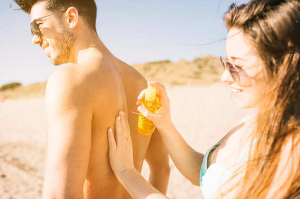 Young Adult Applying Sunscreen at the Beach