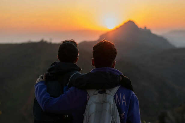 Friends Watching the Sunset From a Highway Stop