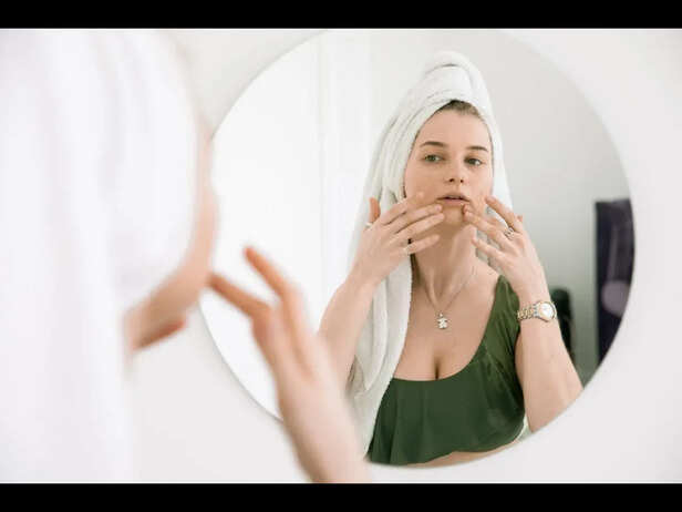 Young Adult Looking Frustrated at Mirror During Skincare Routine
