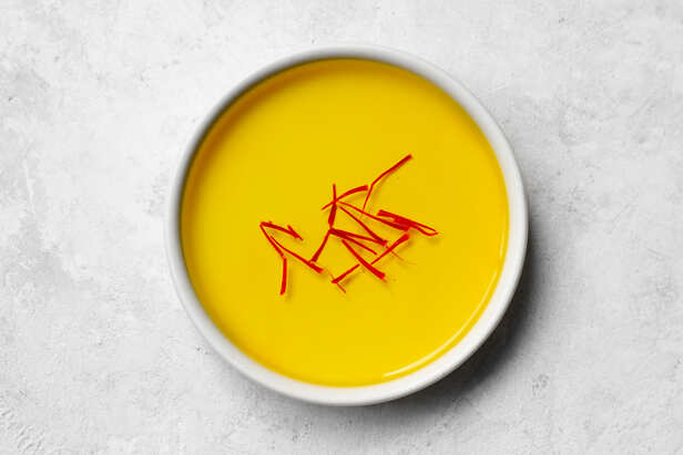 Saffron strands beside a bowl of milk