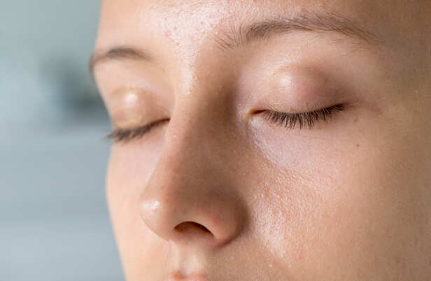 Person Looking at Oily Skin During Monsoon
