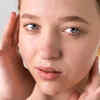 Person Overwashing Face in Front of Mirror