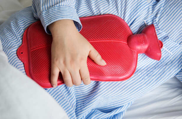 Woman Holding a Hot Water Bag During Period Pain