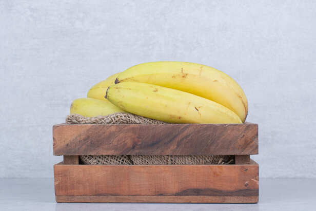Fresh ripe bananas placed on a wooden table