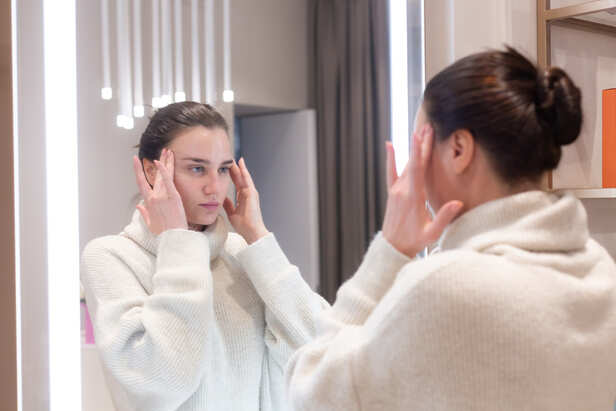 Woman Checking Her Skin in Mirror