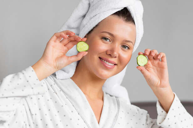 Fresh cucumber slices and lemon beside a glass bowl