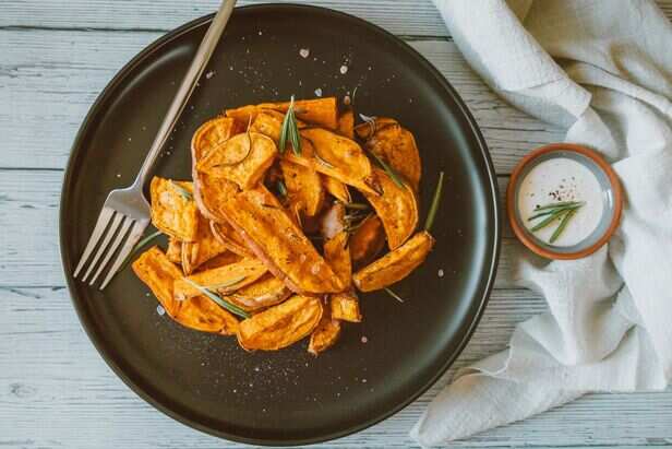 Bowl of roasted sweet potatoes with fresh herbs