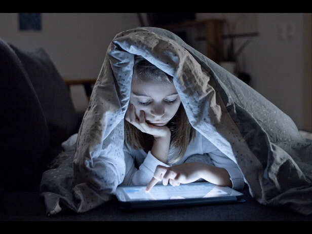 Child Using a Tablet Indoors on a Rainy Day<br>