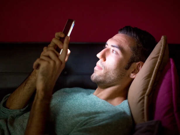 Adult scrolling social media alone at night