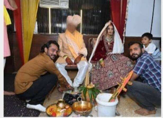 इस फोटो में दुल्हन का असली पति (नीले शर्ट में) अपनी पत्नी के पैर छू रहा है।
