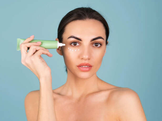 Woman applying eye cream before makeup