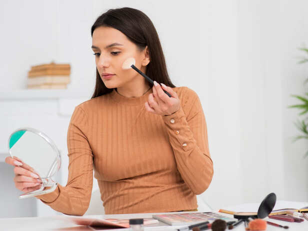 Woman layering multiple skincare products before makeup
