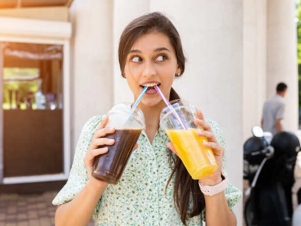 Person drinking a sugary soft drink during a busy day