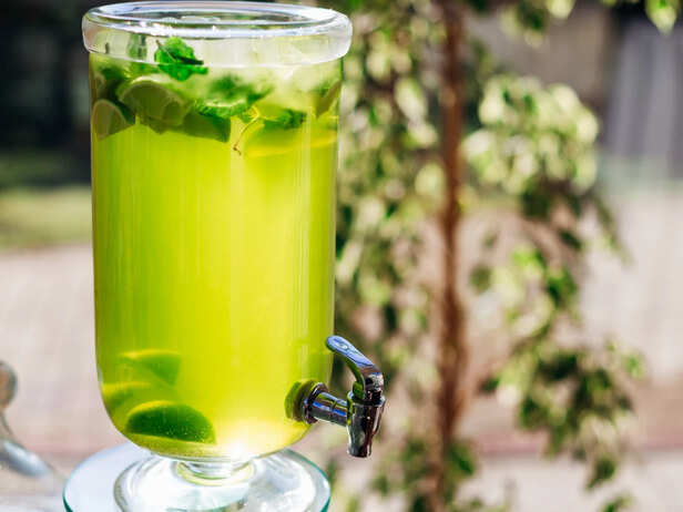 Fresh green amla beside a glass of juice