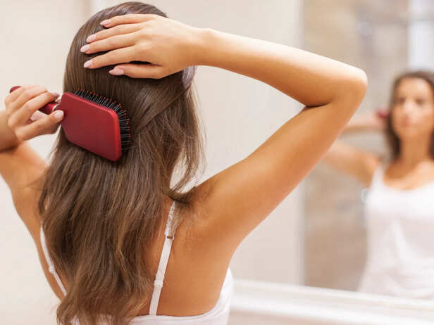 Young Woman Brushing Healthy Hair