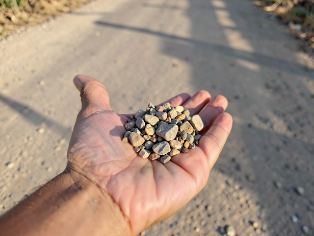 Palm holds dusty road stones